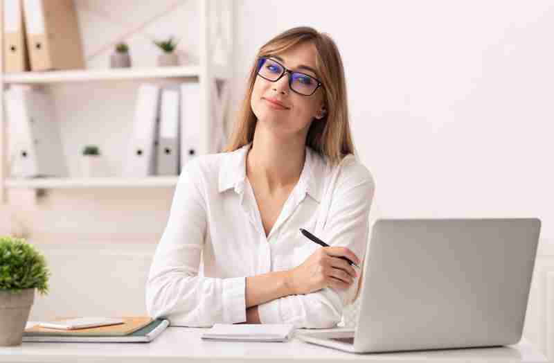 confident-businesswoman-smiling-at-camera-sitting-NHJXPND.jpg