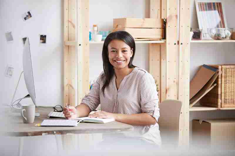 smiling-mixed-race-woman-at-desk-PY2ZLH6.jpg